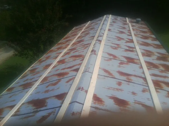Rusted metal roof panels with new wood purlins before replacement — Storm Damage Roof Repair in Lake George by Roofing Brothers