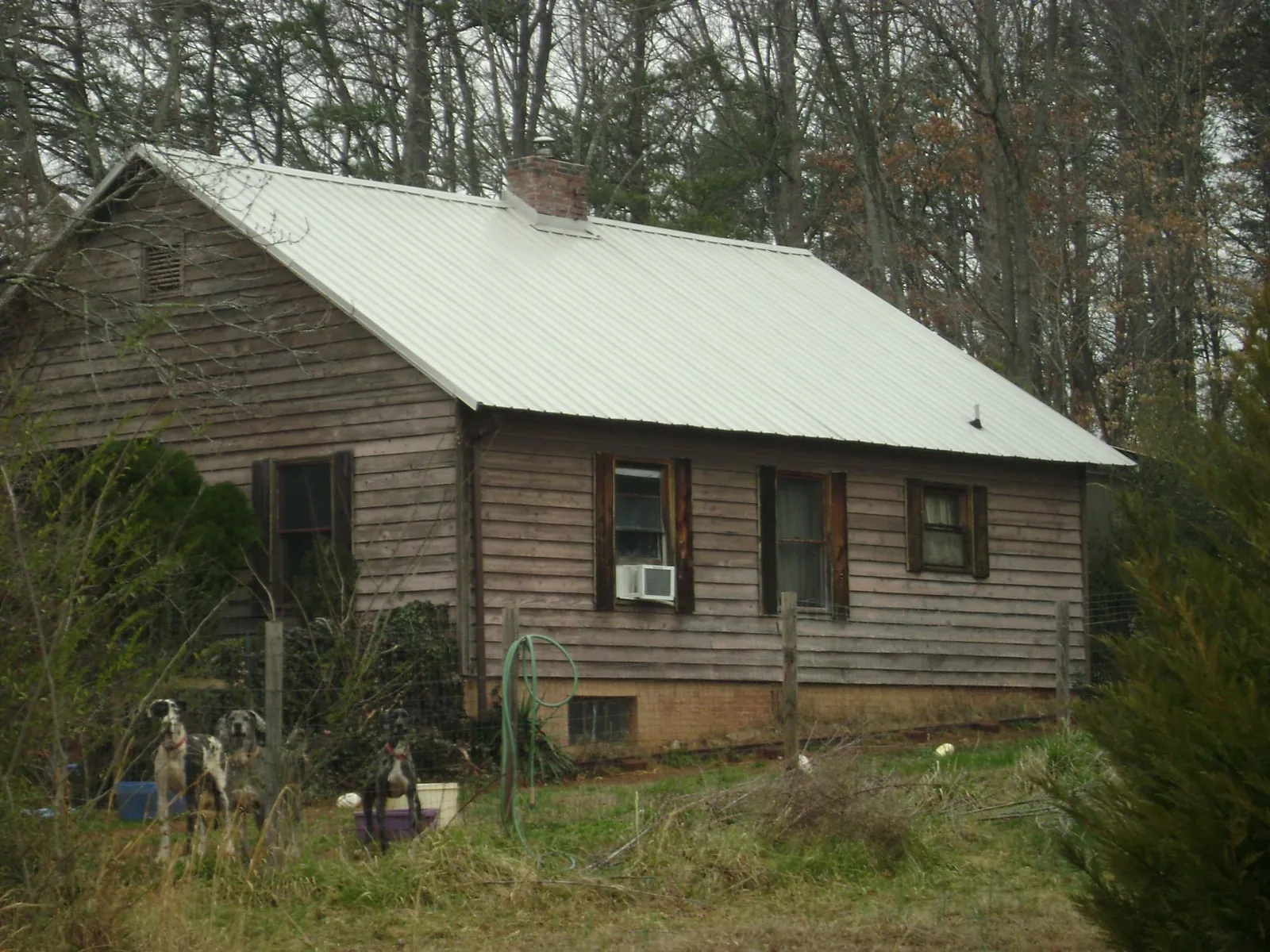 White metal roof on an old wood sided farmhouse, from a Metal Roof Installation job in Lake George